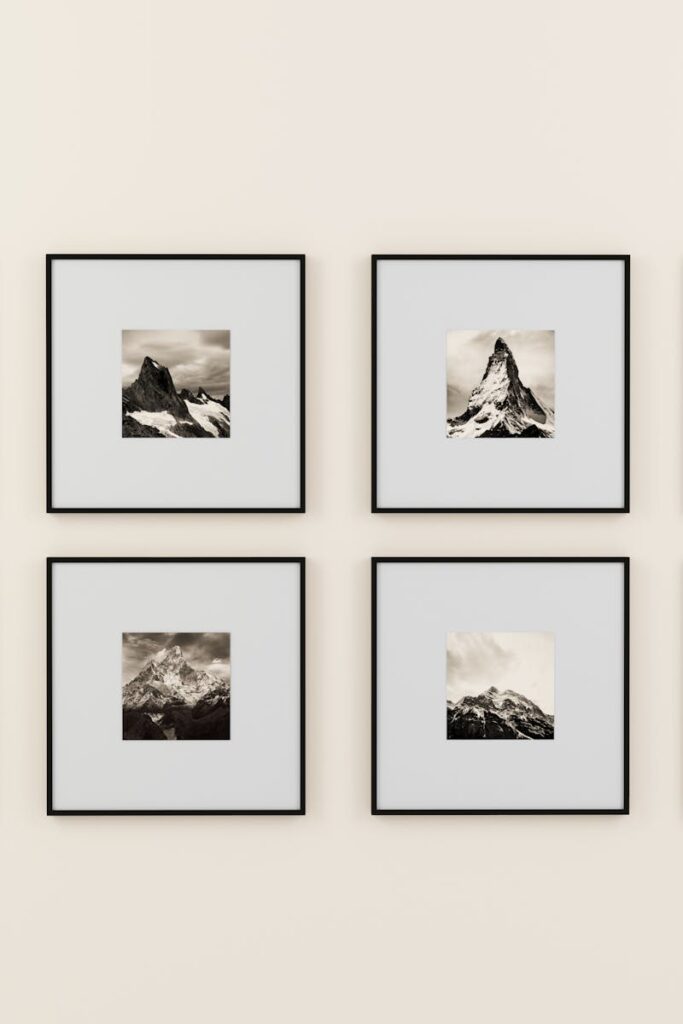 A minimalist display of framed mountain photography on a plain wall.
